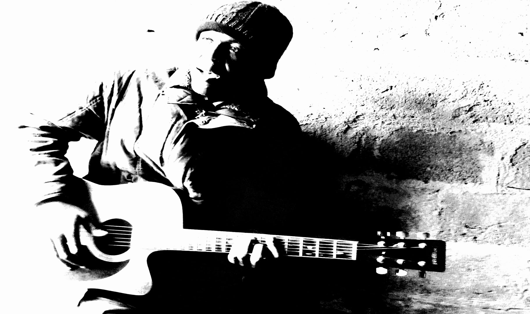 L'artiste camerounais Simon Ngaka avec une guitare acoustique et un bonnet