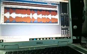 Une bande audio orange visible sur un rack de mastering en symbole à la musique assistée ordinateur