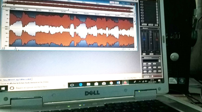 Une bande audio orange visible sur un rack de mastering en symbole à la musique assistée ordinateur